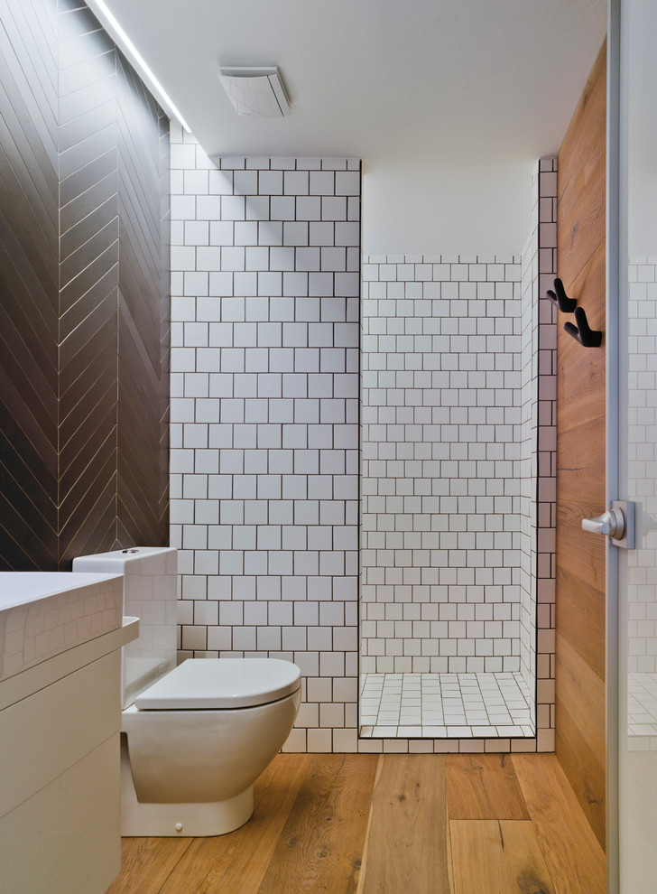 Cette photo montre une salle de bain principale tendance avec un placard à porte plane, une baignoire sur pieds, un carrelage blanc, du carrelage en marbre et un mur blanc.