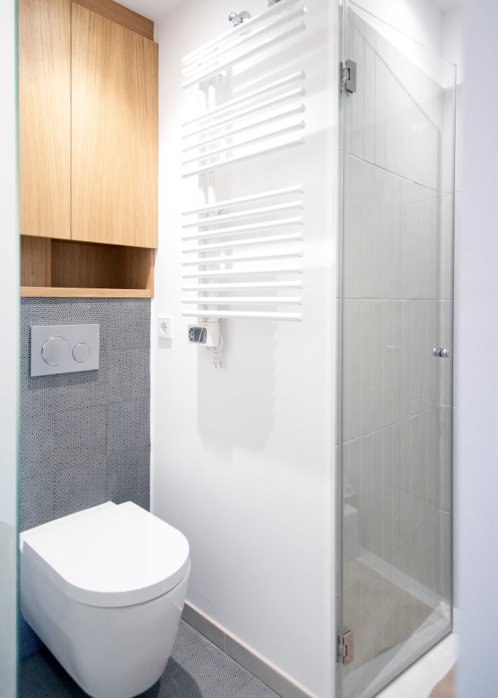 Esempio di una stanza da bagno padronale minimal di medie dimensioni con doccia a filo pavimento, WC monopezzo, piastrelle grigie, pareti bianche, pavimento con piastrelle in ceramica, pavimento grigio e porta doccia a battente