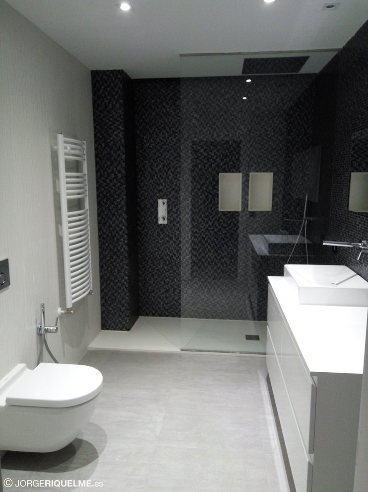 This is an example of a contemporary bathroom in Other with a built-in shower, a wall mounted toilet, white tiles, mosaic tiles, porcelain flooring, a vessel sink and grey floors.