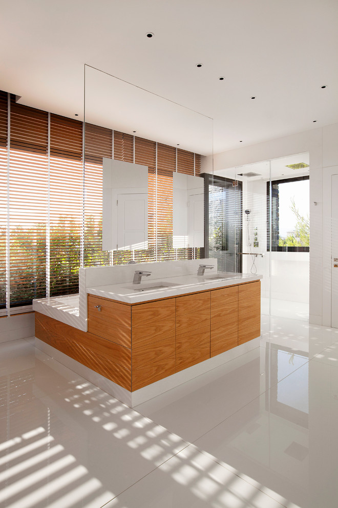 Immagine di un'ampia stanza da bagno con doccia contemporanea con ante lisce, ante in legno scuro, doccia a filo pavimento, pareti bianche e lavabo integrato