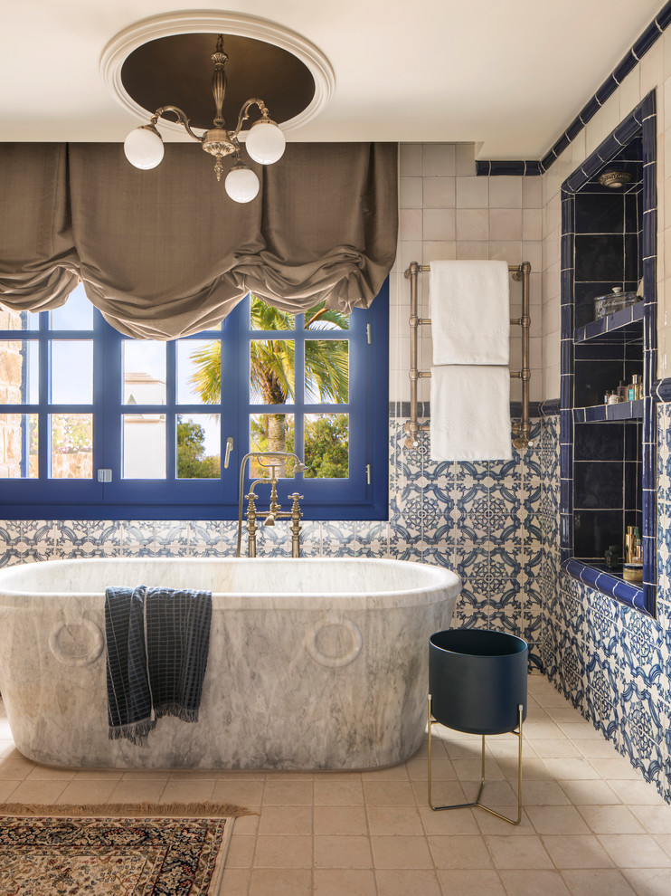 Свежая идея для дизайна: ванная комната среднего размера в стиле фьюжн с отдельно стоящей ванной, душем над ванной, синей плиткой, белой плиткой, керамической плиткой, полом из керамической плитки и белым полом - отличное фото интерьера
