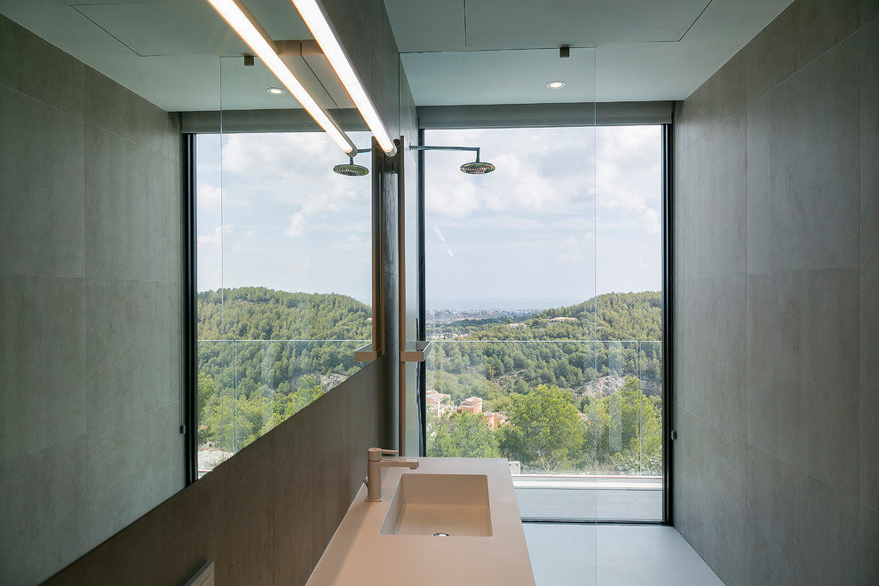 Inredning av ett modernt beige beige en-suite badrum, med en kantlös dusch, grå kakel, grå väggar, ett integrerad handfat, grått golv och med dusch som är öppen