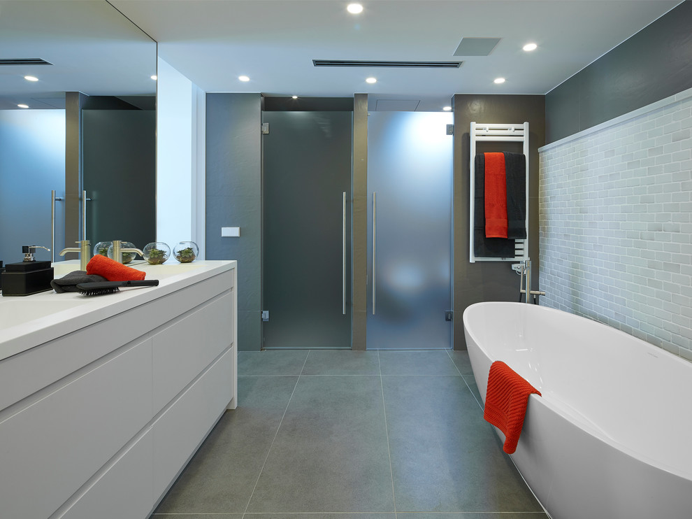 バルセロナにある高級な中くらいなコンテンポラリースタイルのおしゃれなマスターバスルーム (フラットパネル扉のキャビネット、白いキャビネット、置き型浴槽、アルコーブ型シャワー、セラミックタイルの床、一体型シンク) の写真
