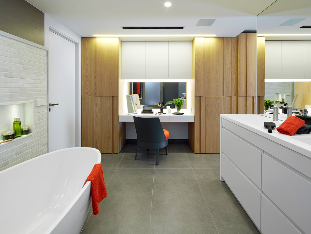 Idéer för funkis en-suite badrum, med släta luckor, vita skåp, ett fristående badkar och klinkergolv i keramik