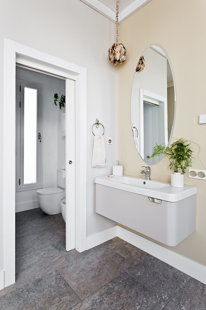 Ispirazione per una stanza da bagno boho chic con lavabo integrato, pavimento grigio e top bianco