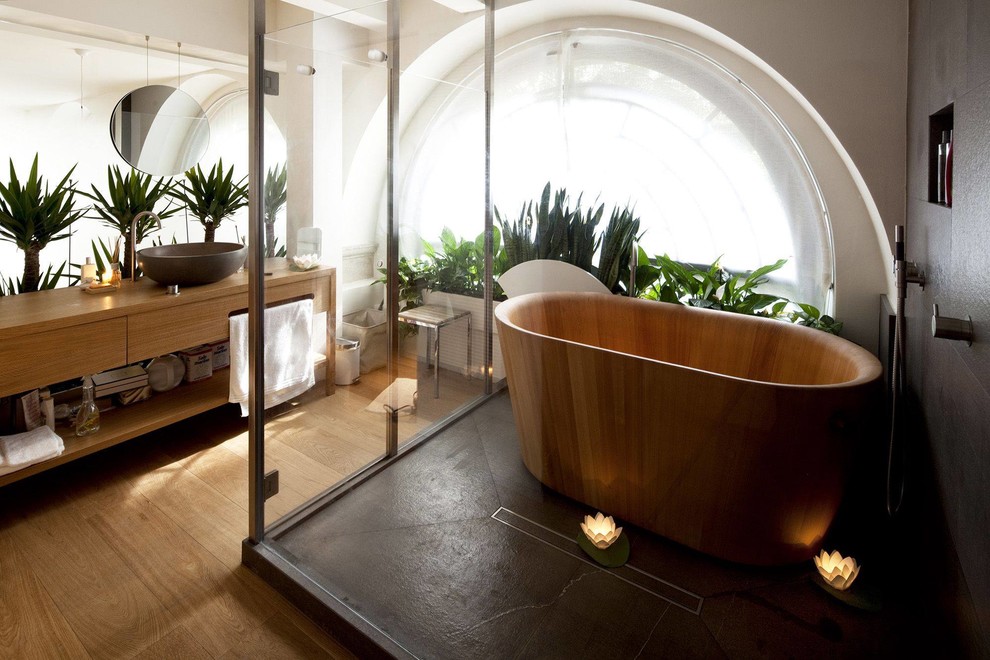 Asiatisk inredning av ett mellanstort en-suite badrum, med skåp i mellenmörkt trä, ett japanskt badkar, en dusch/badkar-kombination, mellanmörkt trägolv, ett fristående handfat, träbänkskiva, släta luckor och vita väggar