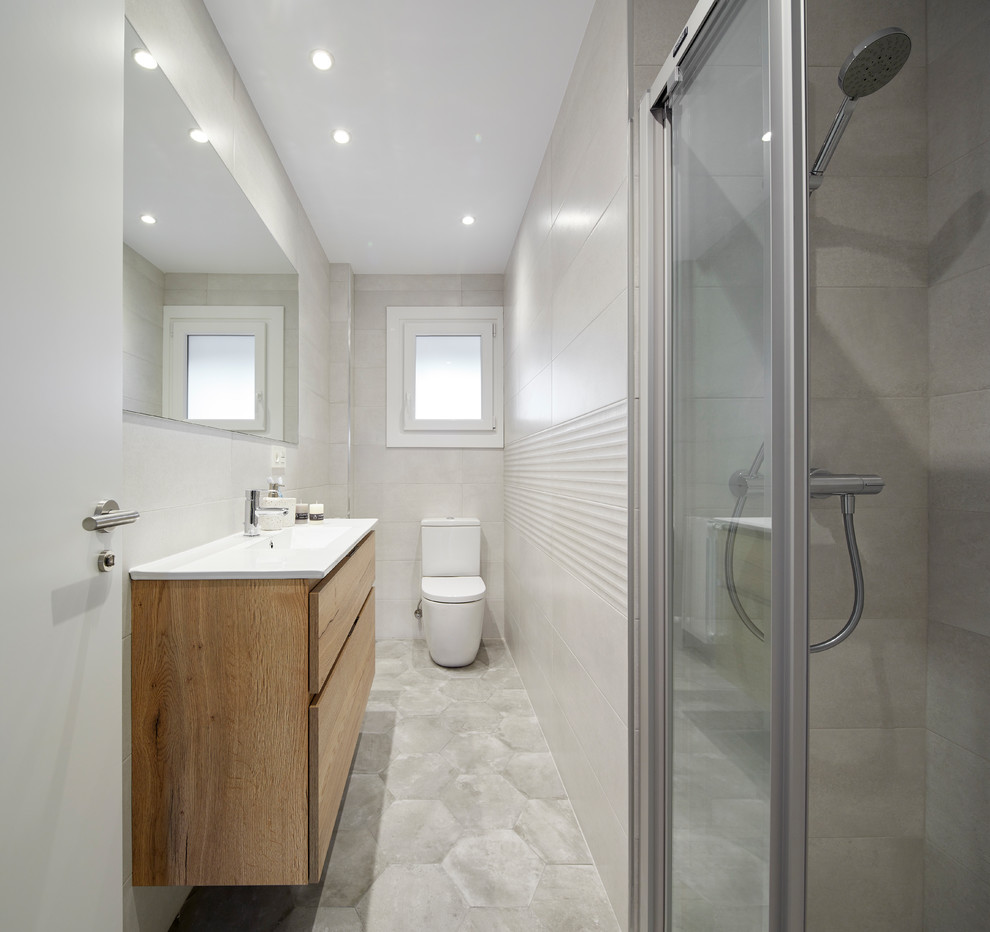 Aménagement d'une salle d'eau scandinave en bois clair avec un placard à porte plane, un carrelage gris, un sol en carrelage de céramique, un sol gris, une cabine de douche à porte coulissante, un mur gris, un lavabo intégré et un plan de toilette blanc.