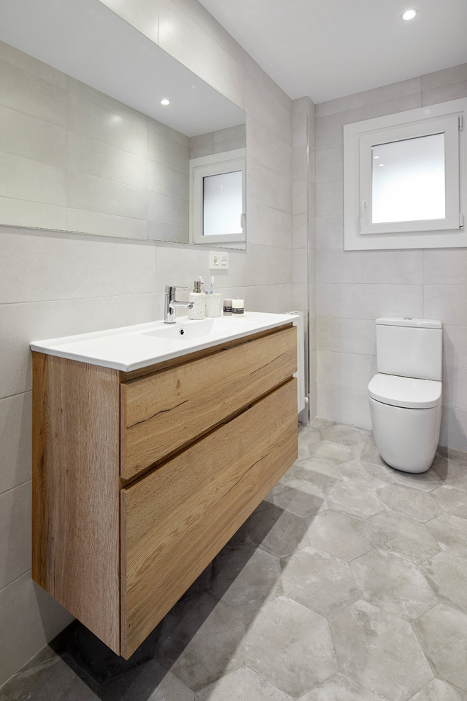 Foto på ett litet minimalistiskt badrum med dusch, med släta luckor, skåp i mellenmörkt trä, en kantlös dusch, en vägghängd toalettstol, grå kakel, cementkakel, klinkergolv i keramik, ett undermonterad handfat, grått golv och dusch med skjutdörr