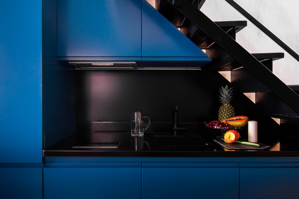 Cette image montre une cuisine design avec un évier intégré, des portes de placard bleues et un plan de travail en zinc.