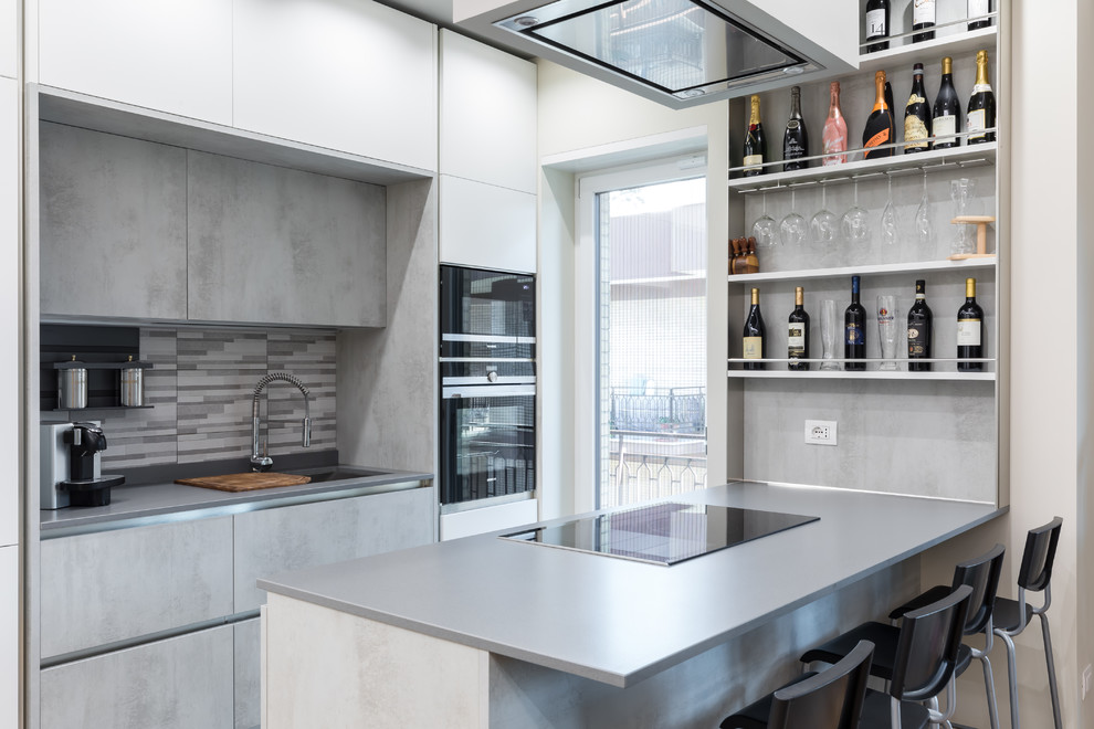 Zweizeilige Moderne Küche mit Unterbauwaschbecken, flächenbündigen Schrankfronten, grauen Schränken, Küchenrückwand in Grau, schwarzen Elektrogeräten und grauer Arbeitsplatte in Rom