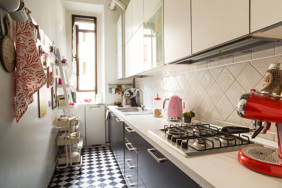ヴェネツィアにある小さな北欧スタイルのおしゃれなキッチン (フラットパネル扉のキャビネット、白いキッチンパネル、パネルと同色の調理設備、セラミックタイルの床、アイランドなし、マルチカラーの床) の写真