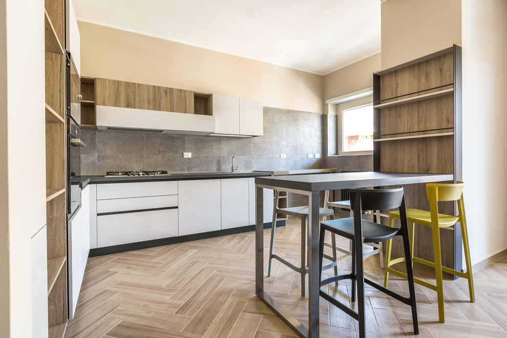Esempio di una cucina a L design con ante lisce, ante bianche, paraspruzzi grigio, top grigio, penisola e pavimento beige