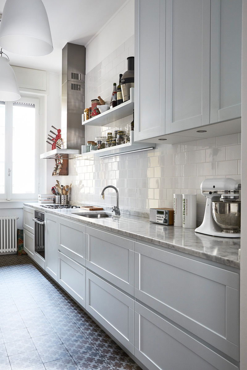 Inspiration för ett mellanstort vintage linjärt kök, med luckor med infälld panel, vita skåp, granitbänkskiva, vitt stänkskydd, rostfria vitvaror, klinkergolv i keramik och flerfärgat golv