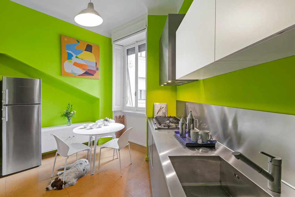 Einzeilige, Mittelgroße Moderne Wohnküche mit integriertem Waschbecken, flächenbündigen Schrankfronten, Edelstahlfronten, Edelstahl-Arbeitsplatte und Küchenrückwand in Metallic in Mailand