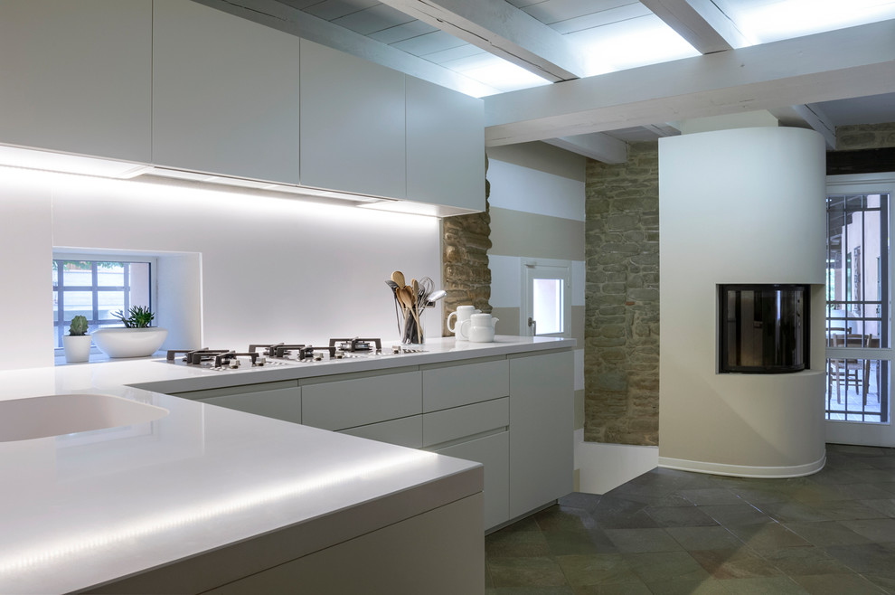 Idéer för att renovera ett mellanstort funkis vit vitt kök, med en integrerad diskho, släta luckor, vita skåp, bänkskiva i koppar, vitt stänkskydd, rostfria vitvaror, skiffergolv och grått golv