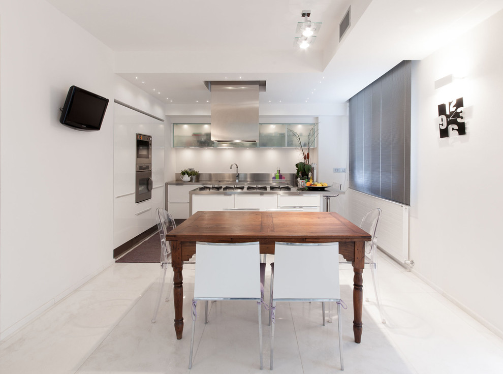 Inredning av ett modernt stort linjärt kök och matrum, med en integrerad diskho, släta luckor, vita skåp, bänkskiva i rostfritt stål, stänkskydd med metallisk yta, stänkskydd i metallkakel, rostfria vitvaror, marmorgolv och en köksö