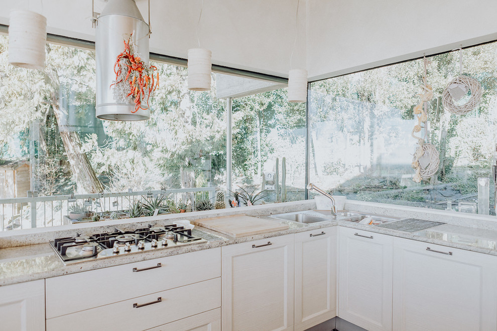 Diseño de cocina contemporánea con fregadero de tres senos, armarios estilo shaker, puertas de armario blancas, salpicadero de vidrio y encimeras grises