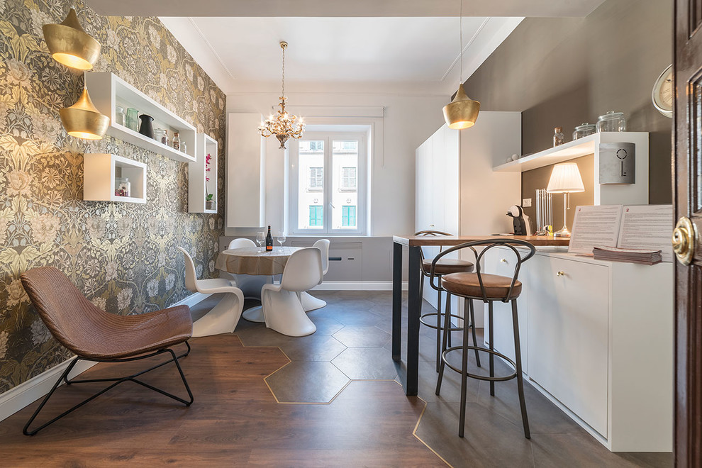 Modern inredning av ett litet linjärt kök och matrum, med släta luckor, vita skåp, en halv köksö, brunt golv och integrerade vitvaror