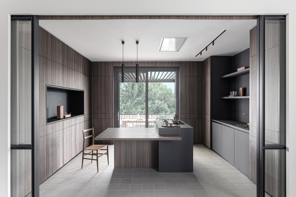 На фото: п-образная кухня в стиле модернизм с накладной мойкой, плоскими фасадами, темными деревянными фасадами, островом, серым полом, серой столешницей и двухцветным гарнитуром