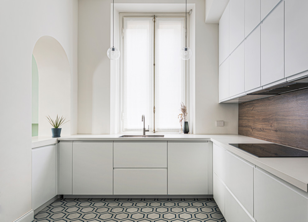 Immagine di una cucina ad U contemporanea con lavello sottopiano, ante lisce, ante bianche, pavimento in cementine, pavimento multicolore e top bianco