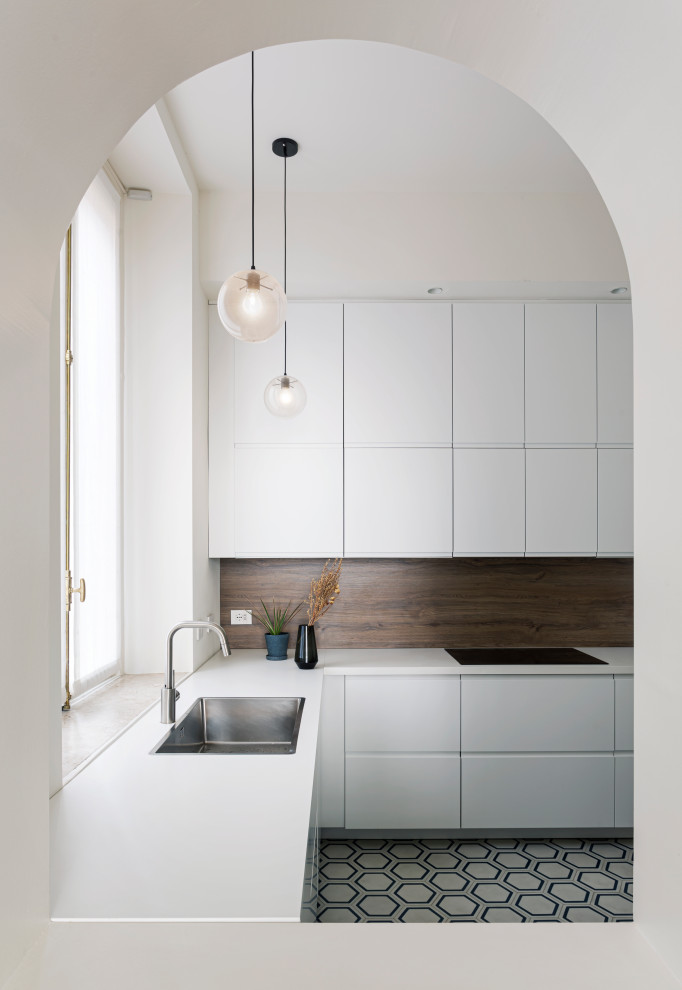 Diseño de cocinas en L tradicional grande con fregadero encastrado, puertas de armario blancas, suelo de azulejos de cemento y encimeras blancas