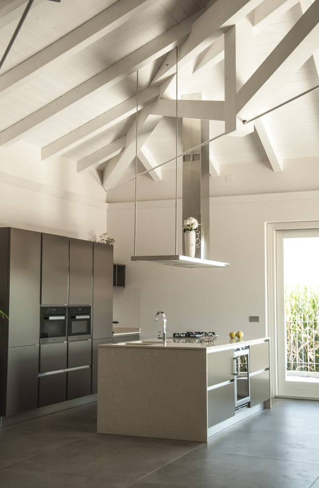 Immagine di una cucina contemporanea con lavello sottopiano, ante lisce, elettrodomestici neri, pavimento grigio, ante grigie, pavimento in cemento e top beige