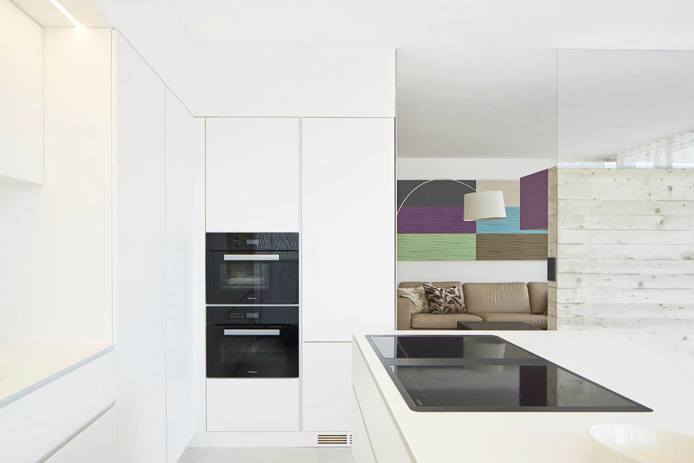 Immagine di una cucina minimalista con lavello da incasso, ante lisce, ante bianche, top in laminato, elettrodomestici neri, pavimento con piastrelle in ceramica e pavimento grigio