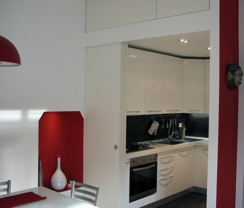 Inspiration för små moderna vitt kök, med en enkel diskho, släta luckor, vita skåp, laminatbänkskiva, svart stänkskydd, stänkskydd i skiffer, rostfria vitvaror, klinkergolv i porslin och brunt golv