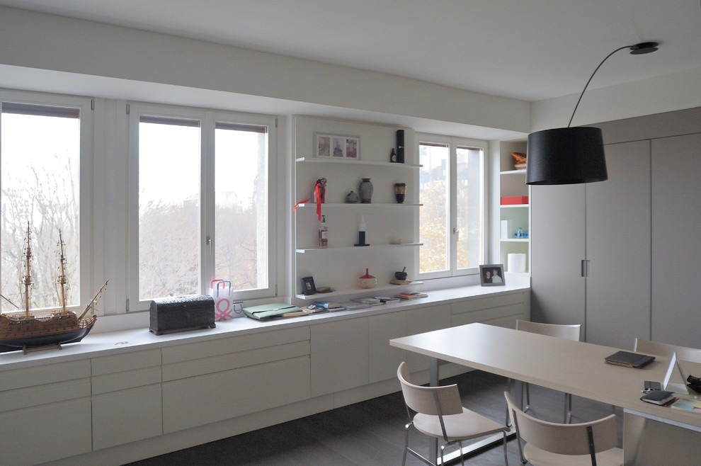 Design ideas for a medium sized contemporary open plan kitchen in Milan with a built-in sink, stainless steel worktops, metallic splashback, stainless steel appliances, dark hardwood flooring and an island.