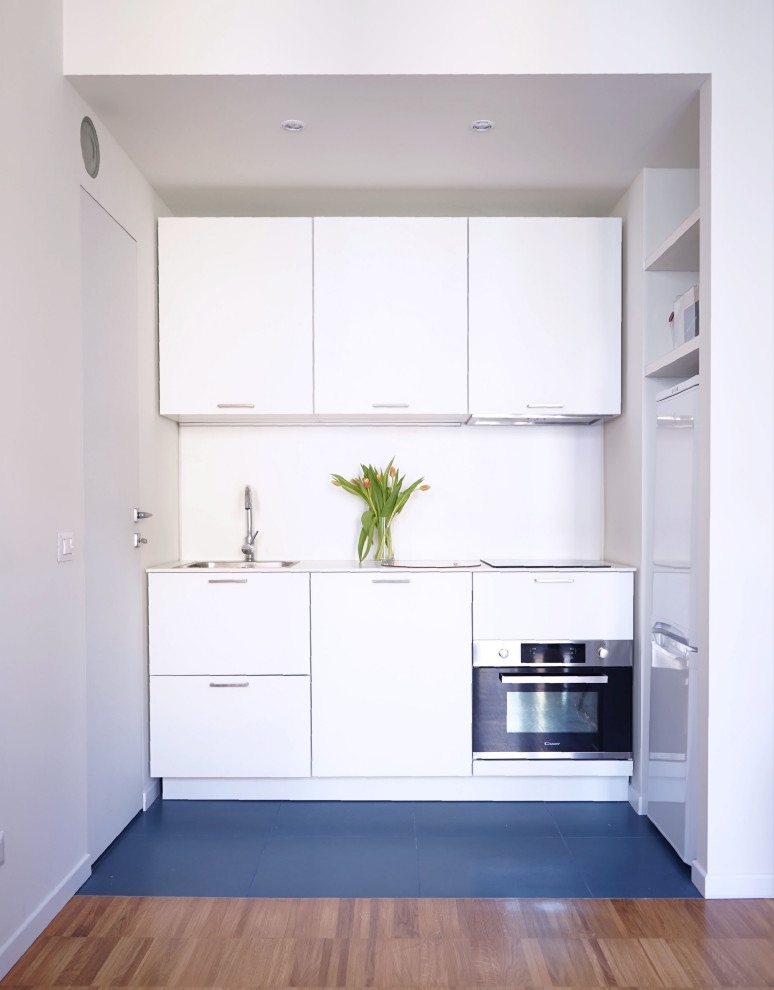 Esempio di una piccola cucina minimalista con lavello da incasso, ante lisce, ante bianche, top in laminato, paraspruzzi bianco, pavimento in gres porcellanato, pavimento blu e top bianco