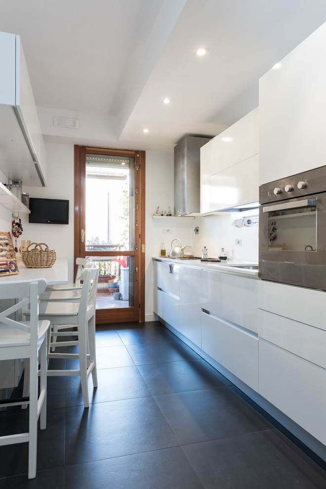Inspiration for a medium sized contemporary single-wall kitchen/diner in Rome with a submerged sink, flat-panel cabinets, white cabinets, quartz worktops, white splashback, stainless steel appliances, porcelain flooring, no island and black floors.