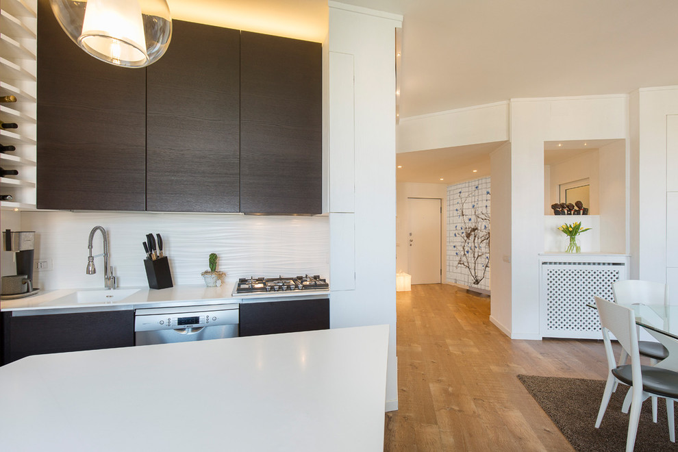 Bild på ett mellanstort funkis vit vitt kök, med en integrerad diskho, luckor med profilerade fronter, skåp i mörkt trä, rostfria vitvaror, en köksö, brunt golv och ljust trägolv