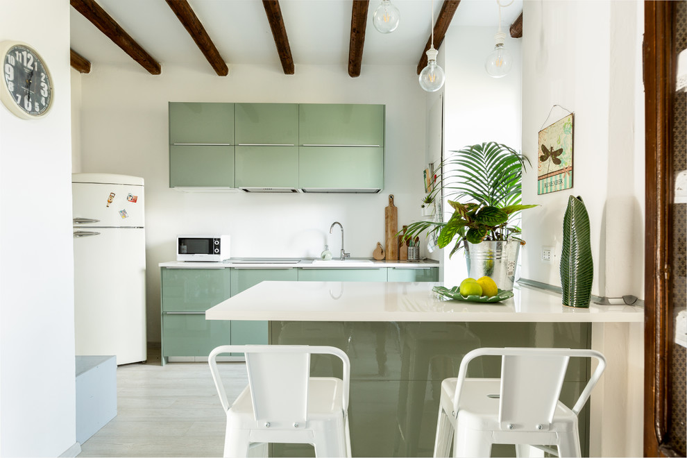 Esempio di una cucina design con lavello da incasso, ante lisce, ante verdi, paraspruzzi bianco, elettrodomestici bianchi, parquet chiaro, penisola e top bianco