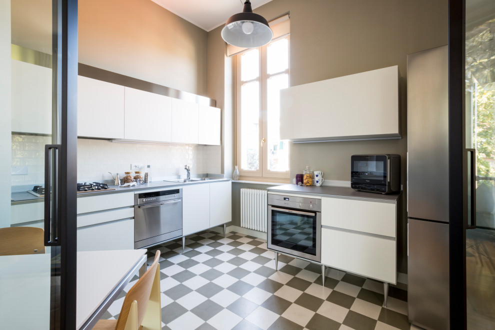Exempel på ett avskilt, litet modernt grå grått l-kök, med en dubbel diskho, släta luckor, vita skåp, laminatbänkskiva, vitt stänkskydd, stänkskydd i keramik, rostfria vitvaror, cementgolv och flerfärgat golv
