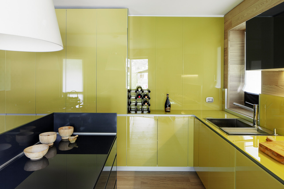 Immagine di una cucina minimal di medie dimensioni con ante lisce, lavello da incasso e parquet chiaro