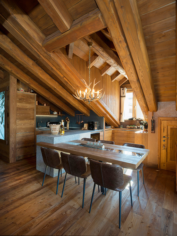 Immagine di una cucina abitabile stile rurale con pavimento in legno massello medio e penisola