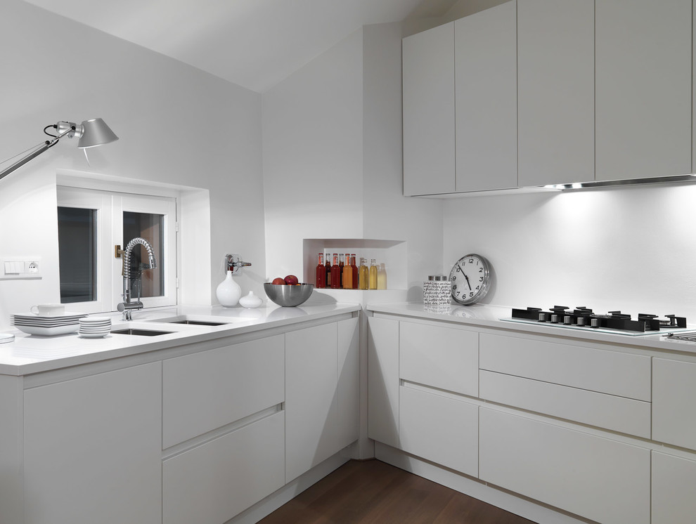 Источник вдохновения для домашнего уюта: угловая кухня в современном стиле с врезной мойкой, плоскими фасадами и белыми фасадами