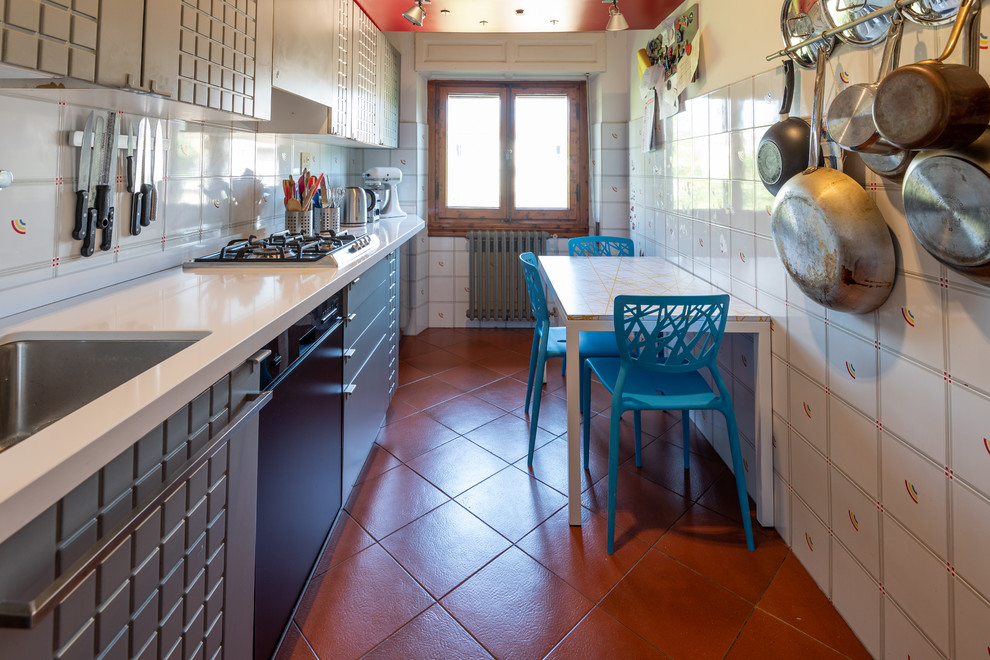 Esempio di una piccola cucina lineare minimalista chiusa con lavello sottopiano, top in quarzo composito, pavimento in terracotta, pavimento marrone e top bianco