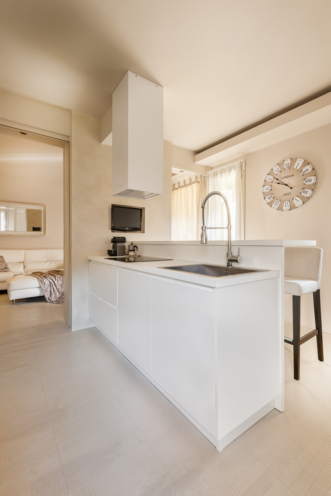 This is an example of a medium sized contemporary kitchen in Milan with a built-in sink, flat-panel cabinets, white cabinets, wood worktops, white splashback, light hardwood flooring and a breakfast bar.