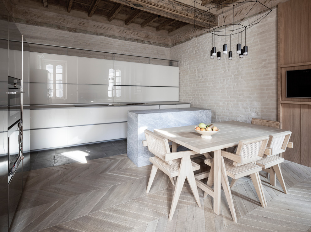 Moderne Wohnküche mit hellem Holzboden, flächenbündigen Schrankfronten, weißen Schränken und Halbinsel in Mailand