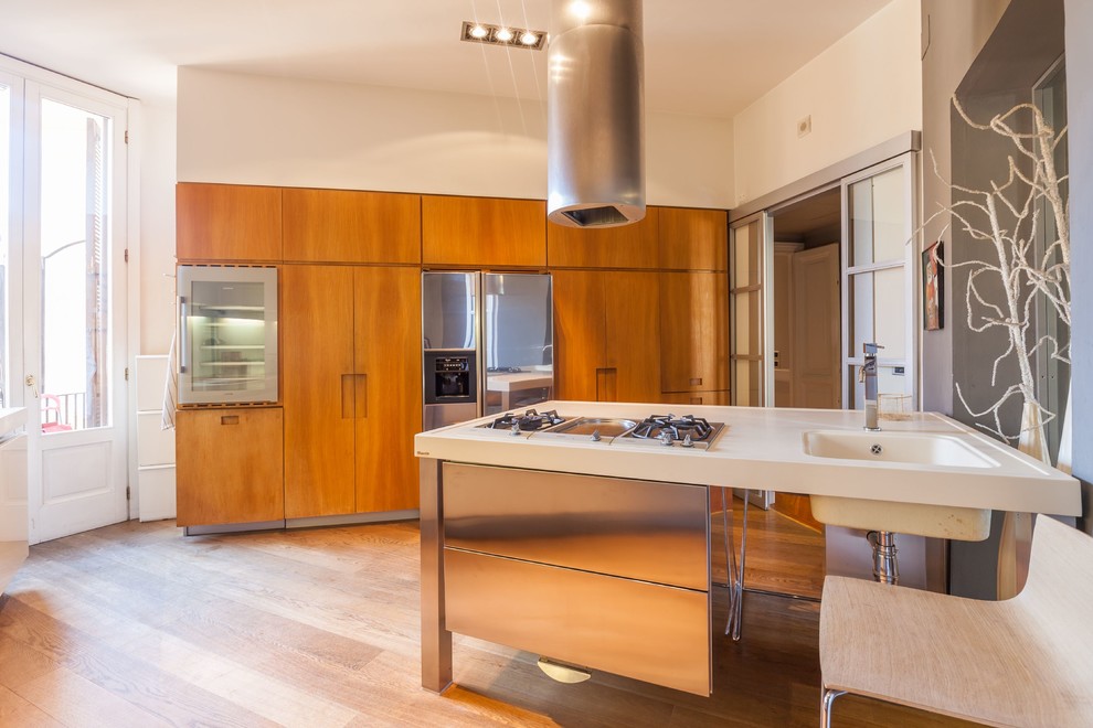 Aménagement d'une grande cuisine linéaire éclectique en bois brun fermée avec un évier intégré, un placard à porte plane, un électroménager en acier inoxydable, un sol en bois brun et une péninsule.