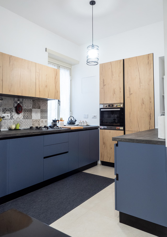 Moderne Küche mit flächenbündigen Schrankfronten, blauen Schränken, bunter Rückwand, schwarzen Elektrogeräten, beigem Boden und grauer Arbeitsplatte in Rom
