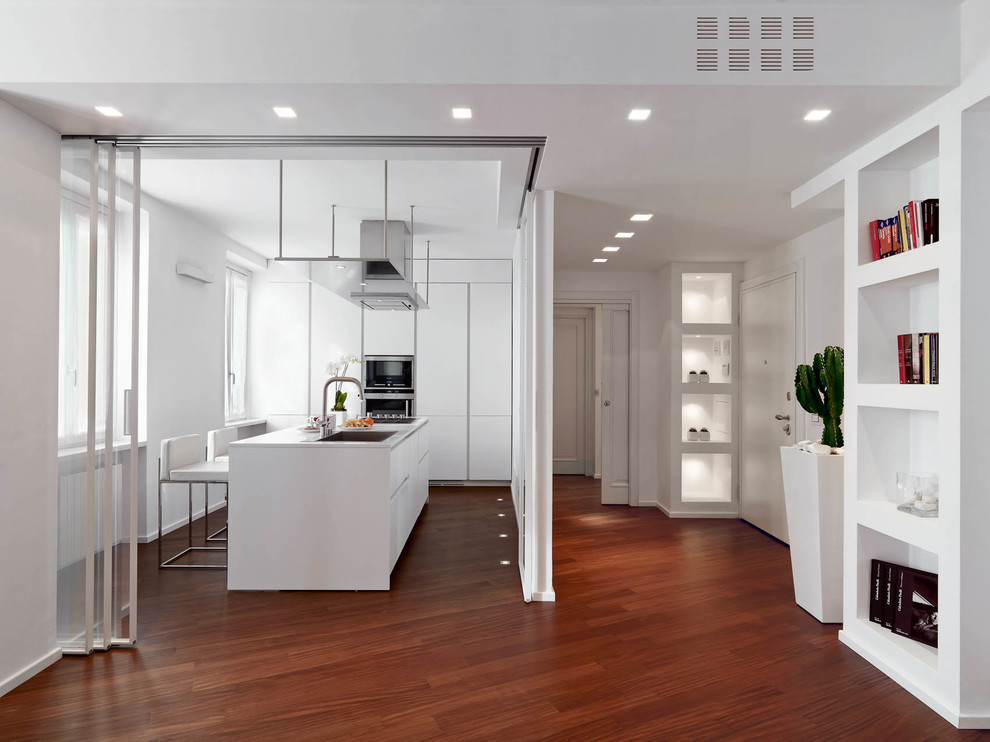 Enclosed kitchen - mid-sized contemporary single-wall dark wood floor and brown floor enclosed kitchen idea in Milan with flat-panel cabinets, white cabinets, quartz countertops, stainless steel appliances and an island