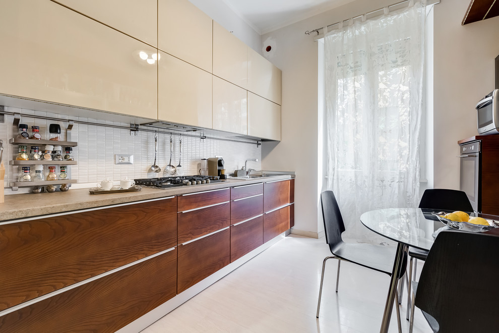 Medium sized modern single-wall kitchen/diner in Rome with a double-bowl sink, flat-panel cabinets, medium wood cabinets, laminate countertops, white splashback, porcelain splashback, stainless steel appliances, laminate floors and beige floors.