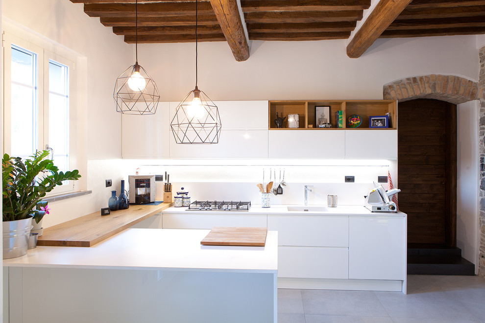 This is an example of a medium sized mediterranean u-shaped kitchen in Other with flat-panel cabinets, white cabinets, white splashback, a breakfast bar, grey floors, an integrated sink, integrated appliances and concrete flooring.