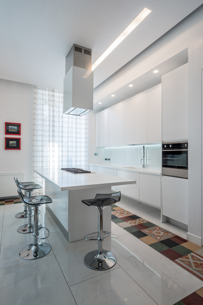 ナポリにある低価格の広いコンテンポラリースタイルのおしゃれなキッチン (フラットパネル扉のキャビネット、白いキャビネット、白いキッチンパネル、セラミックタイルのキッチンパネル、シルバーの調理設備) の写真
