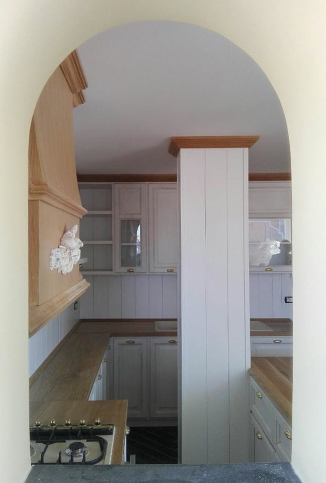 Ejemplo de cocinas en L romántica de tamaño medio abierta con armarios con paneles con relieve, puertas de armario blancas y encimera de madera