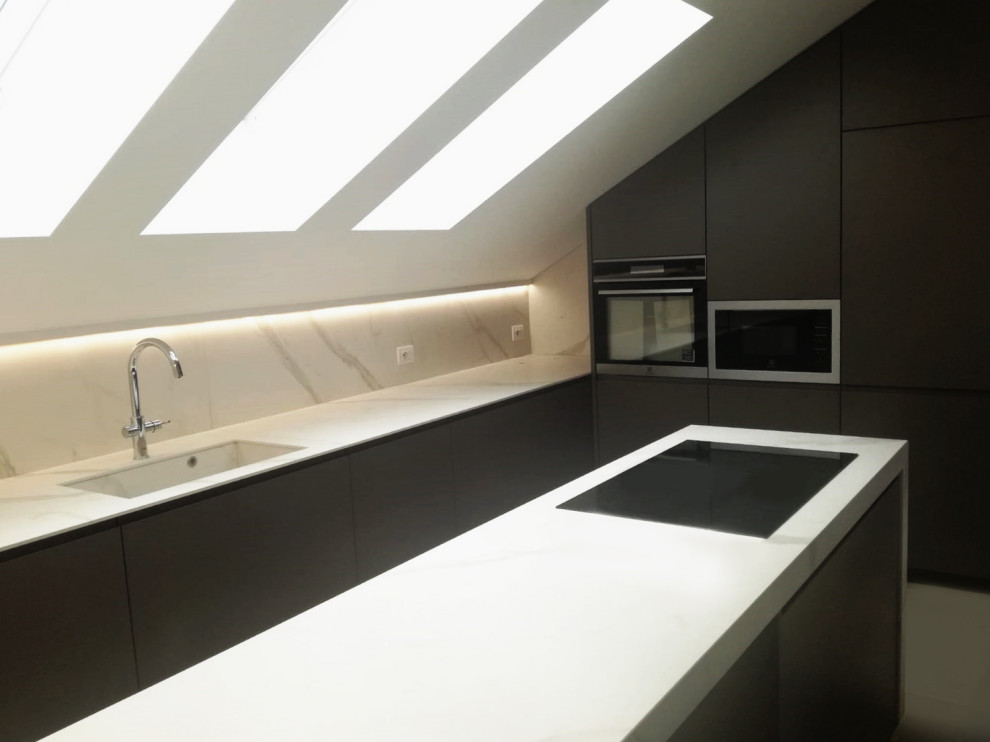 Idée de décoration pour une cuisine design avec des portes de placard blanches, parquet clair et un plan de travail blanc.