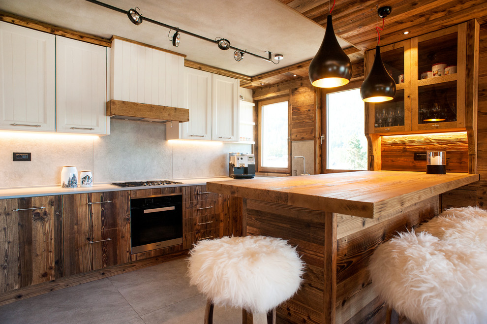 Inspiration for a large rustic l-shaped open plan kitchen in Turin with a single-bowl sink, flat-panel cabinets, stainless steel appliances, porcelain flooring, a breakfast bar, grey splashback, distressed cabinets, marble worktops and porcelain splashback.