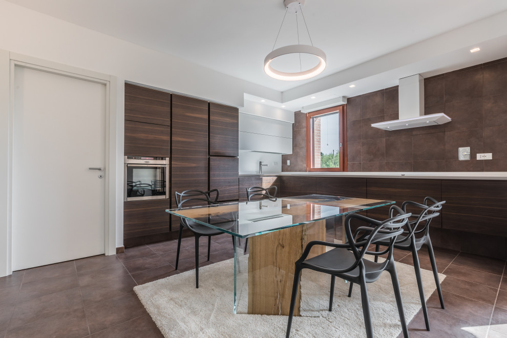 This is an example of a contemporary l-shaped kitchen/diner in Bologna with flat-panel cabinets, dark wood cabinets, brown splashback, stainless steel appliances, no island, brown floors and white worktops.
